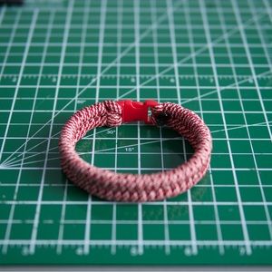 Paracord bracelet in red and white fish tail weave.